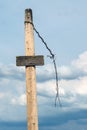 Blank wooden signpost and barbed wire against the sky Royalty Free Stock Photo