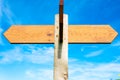 Blank wooden signpost with two arrows over clear blue sky with copy space Royalty Free Stock Photo