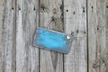 Blank worn blue sign with heart hanging on wood fence