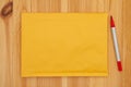 Blank yellow bubble mailing envelope with a marker