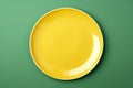 a blank yellow dinner plate on a green studio background Royalty Free Stock Photo