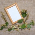 Blank yellow frame, plants and seeds on sackcloth background. Top view flat lay autumn composition. Mock-up