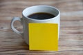 Blank yellow notepad stick on coffee cup with customizable space for text or ideas. Copy space concept. Royalty Free Stock Photo