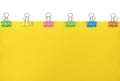 Blank yellow paper with colored paper clips attached around it Royalty Free Stock Photo