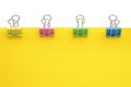 Blank yellow paper with colored paper clips attached around it Royalty Free Stock Photo