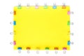 Blank yellow paper sheet with colored small paper clips attached around it Royalty Free Stock Photo