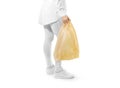 Blank yellow plastic bag mockup holding hand. Royalty Free Stock Photo