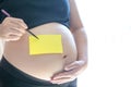 Blank yellow sticker notes on the pregnant woman`s belly. Royalty Free Stock Photo