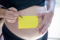 Blank yellow sticker notes on the pregnant woman`s belly. FAQ concept. Royalty Free Stock Photo