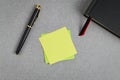 Blank yellow sticky note with black and gold fountain pen and black cover book with red and black bookmark. Royalty Free Stock Photo