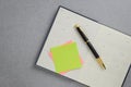 Blank yellow sticky note and black and gold fountain pen placed on calendar notebook. Royalty Free Stock Photo