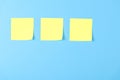 Blank yellow sticky notes on a blue background, concept of business work. Yellow memo stickers on blue wall. Mock-up