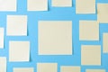 Blank yellow sticky notes on a blue background, concept of business work. Yellow memo stickers on blue wall. Mock-up