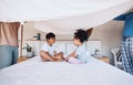 Blanket, cover and children on bed with parents for fun, play or bond in their home. Bedroom, fort and kids with mother Royalty Free Stock Photo