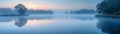 A blanket of fog over a calm lake at dawn