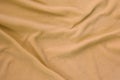The blanket of furry orange fleece fabric. A background of light orange soft plush fleece material with a lot of relief folds Royalty Free Stock Photo