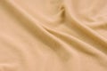 The blanket of furry orange fleece fabric. A background of light orange soft plush fleece material with a lot of relief folds Royalty Free Stock Photo
