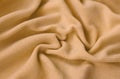 The blanket of furry orange fleece fabric. A background of light orange soft plush fleece material with a lot of relief folds Royalty Free Stock Photo