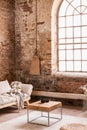 Blanket on grey couch in simple red brick loft interior
