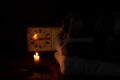 A Blanket And A Pillow Folded In A Stack On A Background Of Fire Candles In A Dark Bedroom
