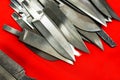 Blanks of combat knives on a red background. The production of melee weapons in a small forge. Close-up