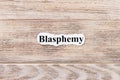 BLASPHEMY of the word on paper. concept. Words of BLASPHEMY on a wooden background