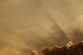 The blasting beam from the clouds in the golden sky at sunset