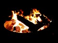 Blazing fire and crackling logs burning brightly in the darkness