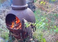 Blazing wood fire outside in a chiminea. Royalty Free Stock Photo