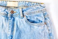 Bleached blue women`s jeans on a white background, trouser pocket close-up. flat lay, top view