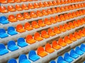 Bleachers, empty seats in the stands of the arena or auditorium. Rows of blue and orange stadium seats without Royalty Free Stock Photo