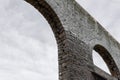 Bleak view of grey skies seen through old stone archways, vintage architectural ruins