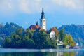 Bled lake island, St Martin Catholic church and Castle. Landscape in Slovenia, nature in Europe. Foggy Triglav Alps with forest,