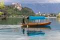 Bled, Slovenia - May 18, 2019 : men rowing a traditional slovenian wooden boat called `pletna` for transporting people,