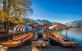 Bled, Slovenia - Traditional red, orange and blue Pletna boats in the autumn sunshine