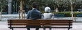 Blend of humanity and artificial intelligence, intimate moment of a man and an AI robot sitting side by side on a bench.