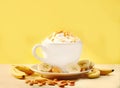 Blended Banana Coffee in white porcelain cup with fragrant collagen cream on yellow background. Generative Ai content