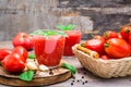 Blended fresh tomato juice with basil leaves in glasses and ingredients for its preparation