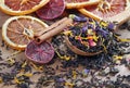 Blended tea. black tea with dry flower petals and citrus fruits. dry black tea leaves in a wooden spoon. close up Royalty Free Stock Photo