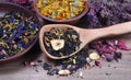 Blended tea with flower petals and dried fruit in a wooden spoon. close up Royalty Free Stock Photo