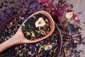 Blended tea with flower petals and dried fruit in a wooden spoon. close up Royalty Free Stock Photo