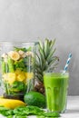 Blender with fresh juicy fruits, spinach, avocado, chia seeds for making healthy detox drink and glass of green smoothie Royalty Free Stock Photo