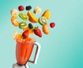 Blender with fruit flying, on blue background