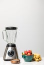 Blender near sweet strawberries in bowl Royalty Free Stock Photo