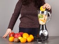 Blender, woman, fruits and gray background Royalty Free Stock Photo