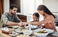 Bless this food and our family. a young family holding hands in prayer before having a meal together outdoors. Royalty Free Stock Photo
