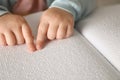 Blind child reading book written in Braille