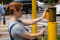 Blind woman pressing a button for a traffic light.