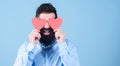 Blind love. Hipster covering eyes with small hearts. Bearded man holding red hearts. Sexy man with heart shaped