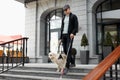 Blind man with disability walking down the stairs with a guide dog